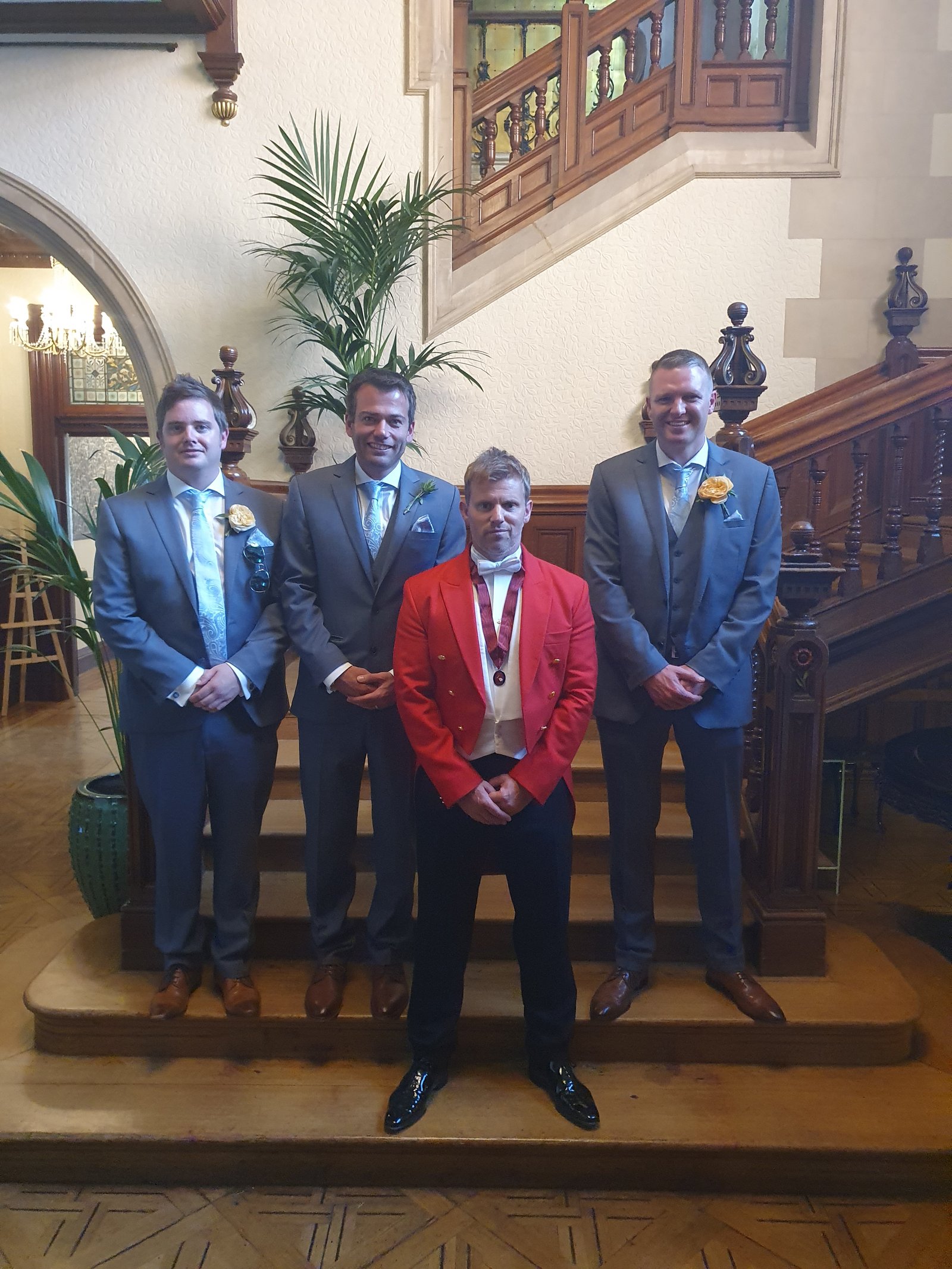 Ross toastmaster with wedding groomsmen on grand staircase